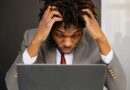 an exhausted man working in front of his laptop