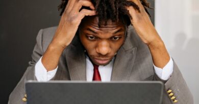 an exhausted man working in front of his laptop
