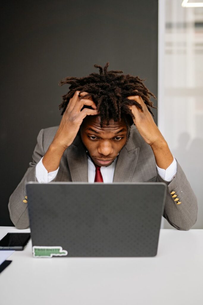 an exhausted man working in front of his laptop
